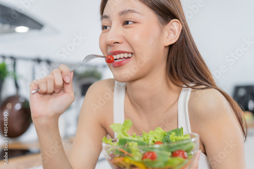 Diet, Dieting asian young woman or girl use fork at tomato on mix vegetables, green salad bowl, eat  food is low fat good health. Nutritionist female, Weight loss for healthy person.