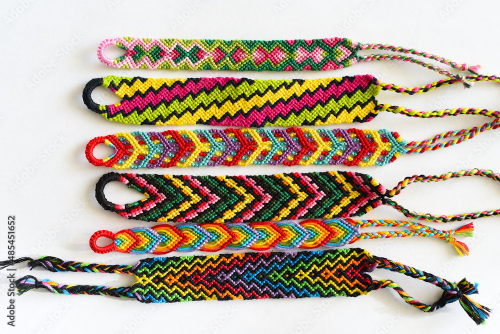 Tied DIY friendship bracelet with unusual braiding pattern on white background