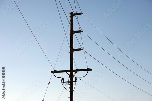 Electricity distribution pylon and power lines under blue sky