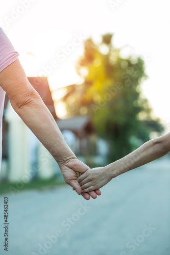 parent holds the hand of a small child