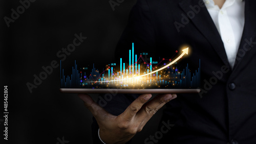 Businessman holding tablet and analysis stock market, graph and chart, Business growth and strategy concept.