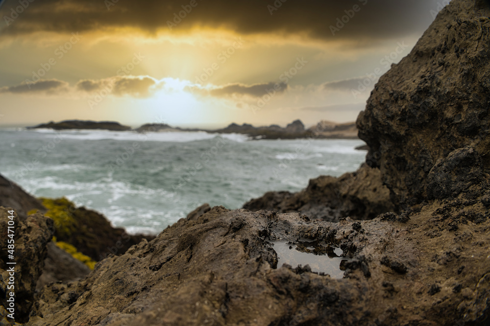 sunset in the sea with rocks covered with vegetation