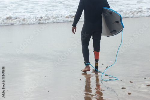 Photography Back view of sporty man walking on beach