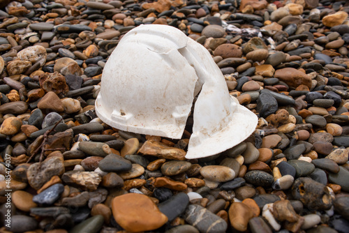 broken hardhat lying on stones