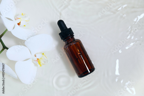 bottle of essential oil with white orchid