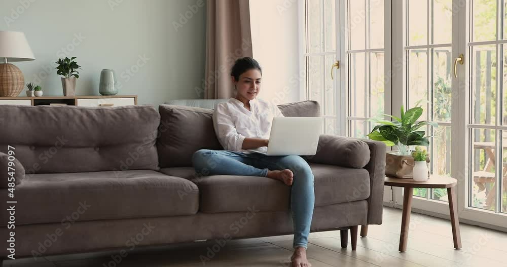 Pensive Indian freelancer woman sit on sofa with laptop working remotely, do telecommute distancing job from home, search ideas, consider over online task, looking thoughtful. Challenge, tech concept Pensive Indian freelancer woman sit on sofa with laptop working remotely, do telecommute distancing job from home, search ideas, consider over online task, looking thoughtful. Challenge, tech concept