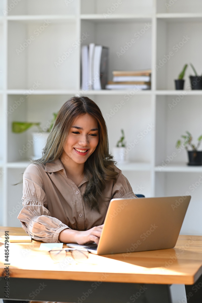 Portrait attractive asian woman sitting in bright modern office and working with laptop computer. Portrait attractive asian woman sitting in bright modern office and working with laptop computer.