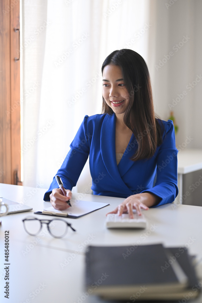 Portrait of cheerful asian business woman working in bright office. Portrait of cheerful asian business woman working in bright office.