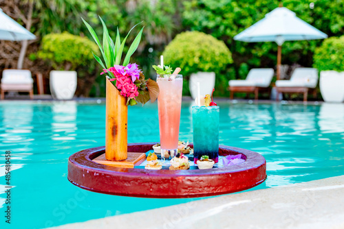 served floating tray in swimming pool with drinks and snacks on tropical island resort in Maldives, cocktails and canapes for romantic date or honeymoon in luxury hotel, travel concept