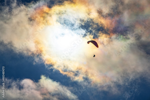 Paragliding adventure sport against bright sun on cloudy sky © YouraPechkin