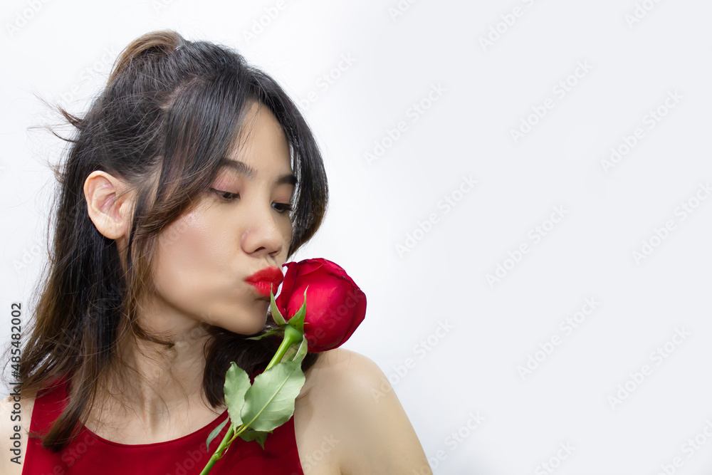 Asian beautiful woman are holding  red rose in front of  her face and look away . Valentine day and Love
