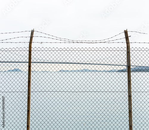 fence with wire in front of the sea