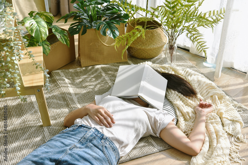 Woman chilling and sleeping in living room, Artificial plant, Indoor tropical natural houseplant for home interior and air purification.