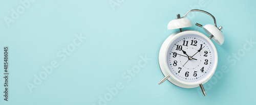 Top overhead panoramic close up view photo of classic white alarm clock showing time isolated pastel color backdrop with blank space