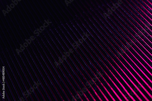 Ridged texture. Blur glow overlay. Fluorescent light reflection. Neon pink purple color gradient radiance on dark black grooved surface abstract background.