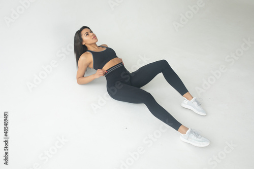 Attractive black african american woman in stylish fitness outfit top and pants on white isolated background.