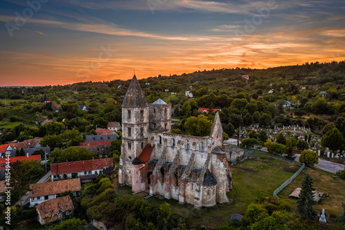 Zsambek, Hungary - Aerial view of the beautiful Premontre Monastery ruin church of Zsambek (Schambeck) with cemetery and colorful dramatic sunset at background at summertime