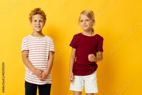 two joyful children cuddling fashion childhood entertainment yellow background