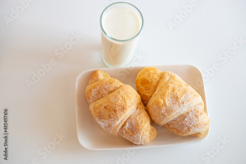 Delicious breakfast with fresh croissants, orange juice and a glass of milk.