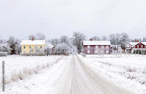 Farm barn and house in a cold winter landscape with snow and frost