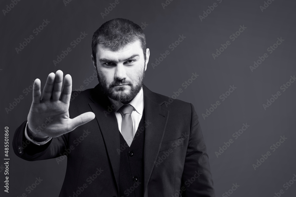 Stop. Stop hand sign. The man in the suit put his palm forward. Stop signal. Hand gesture Stop. Stop hand sign. The man in the suit put his palm forward. Stop signal. Hand gesture