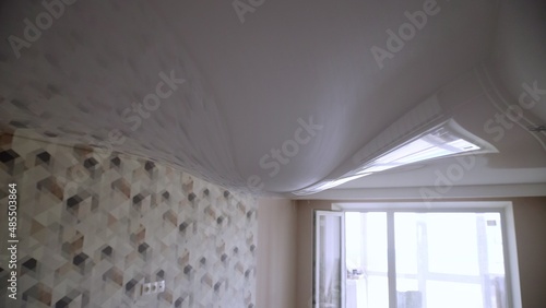 Stretch ceiling in the room filled with water. Flood, water leakage from the ceiling in the apartment.