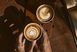 Man holding coffee cup with latte art,