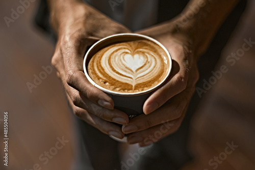 Man holding coffee cup with latte art 