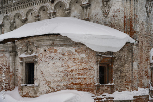 Close-up of the brick walls of a dilapidated church with patterned historical masonry, columns, open windows on a winter day. Solikamsk, Northern Urals, Russia  photo