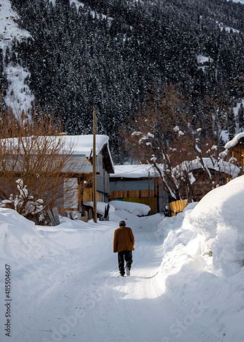 old man walking on snow covered road.Artvin. Turkey