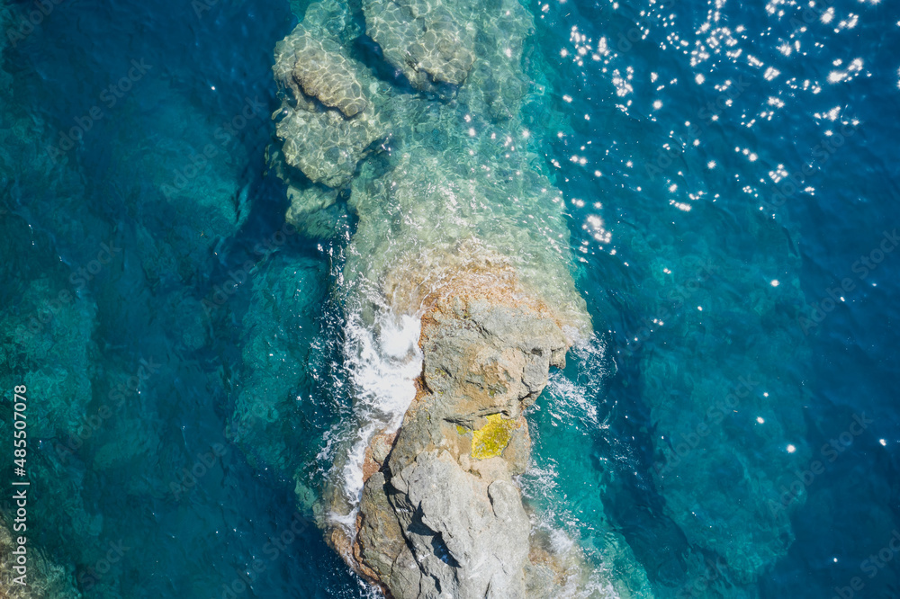 Aerial view of sea waves and fantastic Rocky coast, Italy. Rock and sea. Clear amazing azure colour sea water with granite rocks in beach, Italy. Stone rock close up in the sea water.