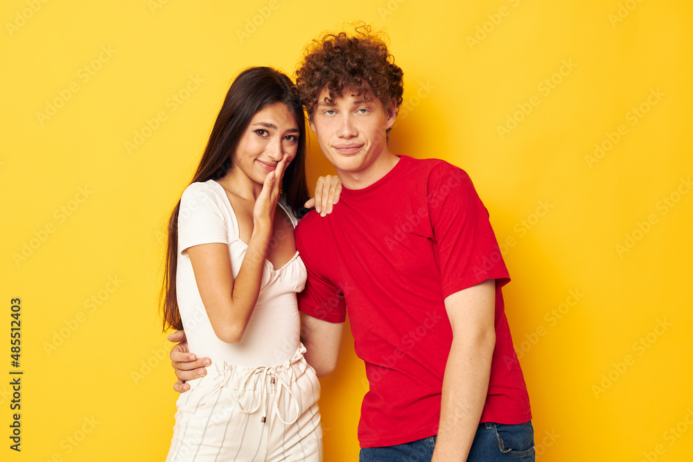Naklejka premium cute young couple Friendship posing hugs together yellow background unaltered