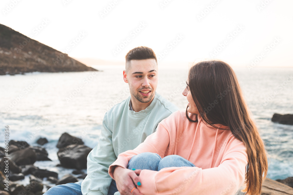 Young caucasian couple chatting at the sea side.