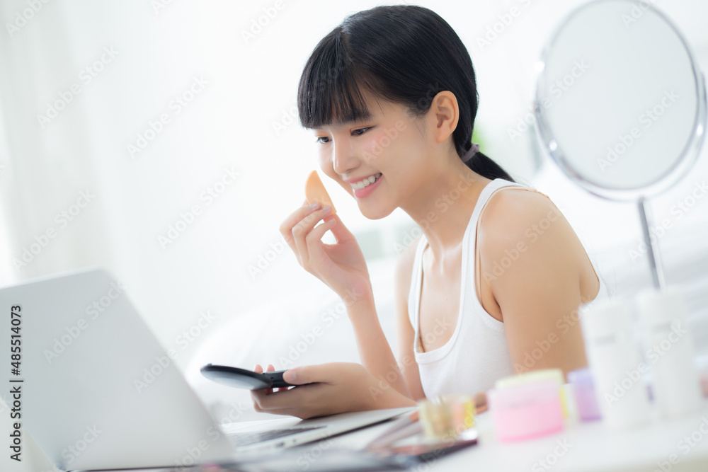 Beauty of young asian woman with learning makeup with powder puff on cheek watching laptop computer with tutorial course online, female teaching and explain make up with cosmetic on streaming media. Beauty of young asian woman with learning makeup with powder puff on cheek watching laptop computer with tutorial course online, female teaching and explain make up with cosmetic on streaming media.