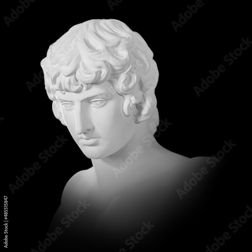 Gypsum copy of famous ancient statue Antinous bust isolated on a black background with clipping path. Plaster antique sculpture young man face. Renaissance epoch. Portrait photo