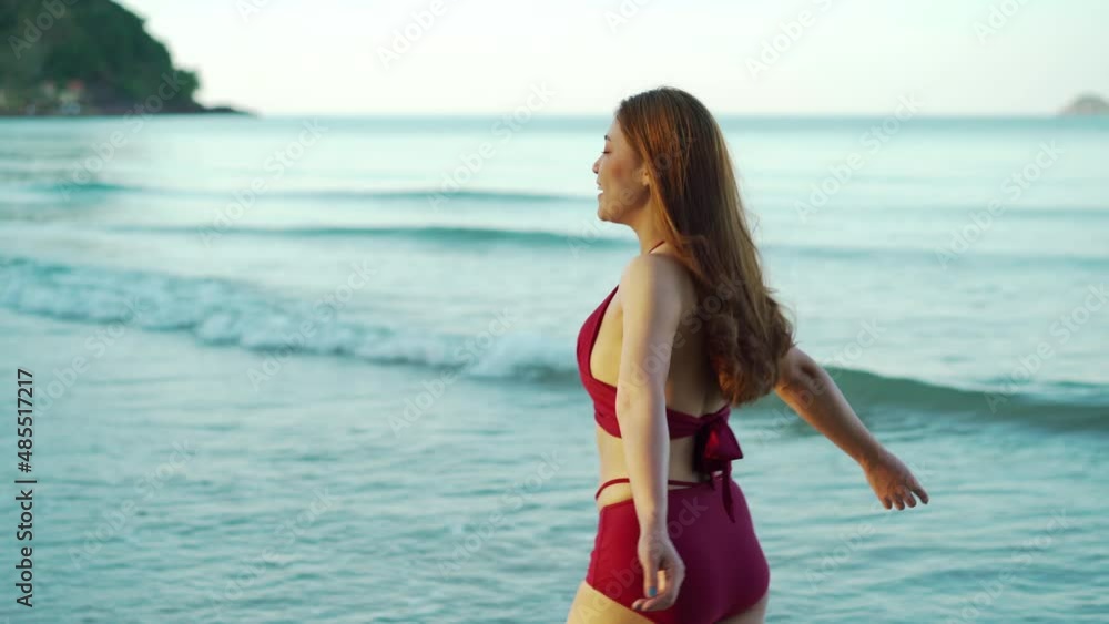happy young woman in swimsuit walking on the sea beach at Koh Chang island, Thailand happy young woman in swimsuit walking on the sea beach at Koh Chang island, Thailand