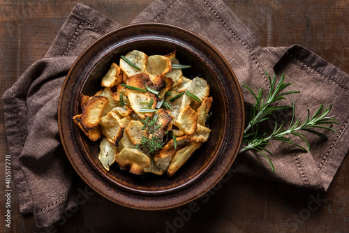 Crispy Jerusalem Artichoke chips garnished with rosemary on table