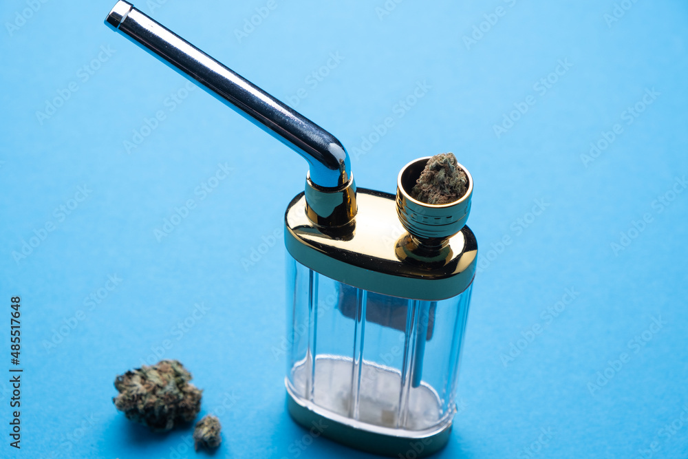 Obraz premium Hookah with marijuana on a blue background close-up.