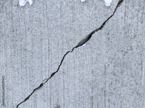 diagonally cracked concrete. texture and background photo.