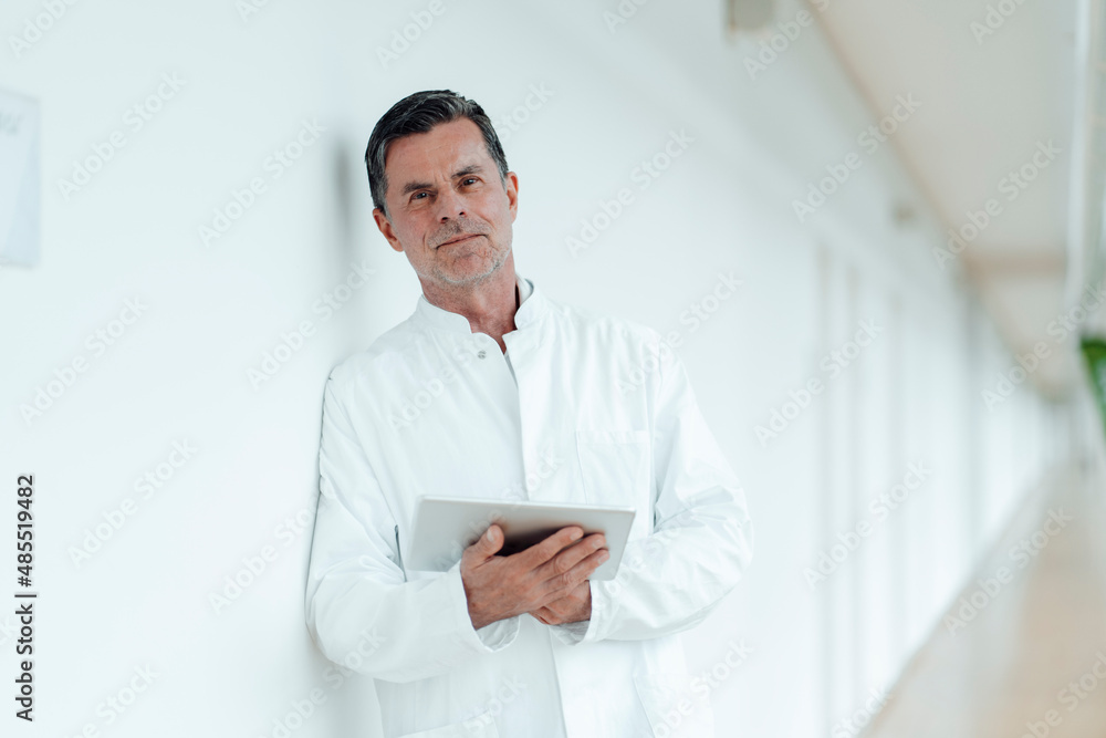 Scientist with tablet PC leaning on wall at medical clinic Scientist with tablet PC leaning on wall at medical clinic