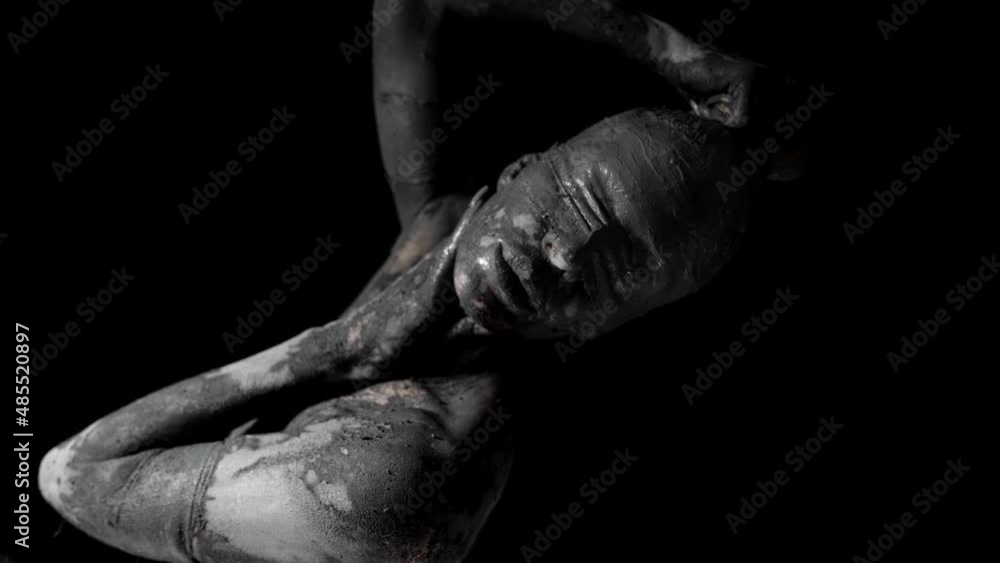 strange woman covered by grey clay and blindfolded in darkness, mysterious life statue strange woman covered by grey clay and blindfolded in darkness, mysterious life statue