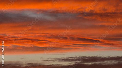 Dramatic bloody fire sky. Fantastic golden sunset background. Abstract dark red blurred background. Panoramic view. Specially defocused photo.