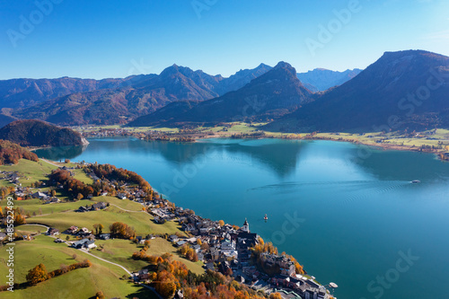 Austria, Salzburg, Sankt Wolfgang im Salzkammergut, Drone view of Lake Wolfgang and surrounding village in autumn