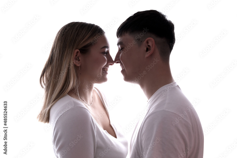 Boyfriend and girlfriend face to face looking at each other at backlight.  Young couple at home. Heterosexual 18-20 years old couple.