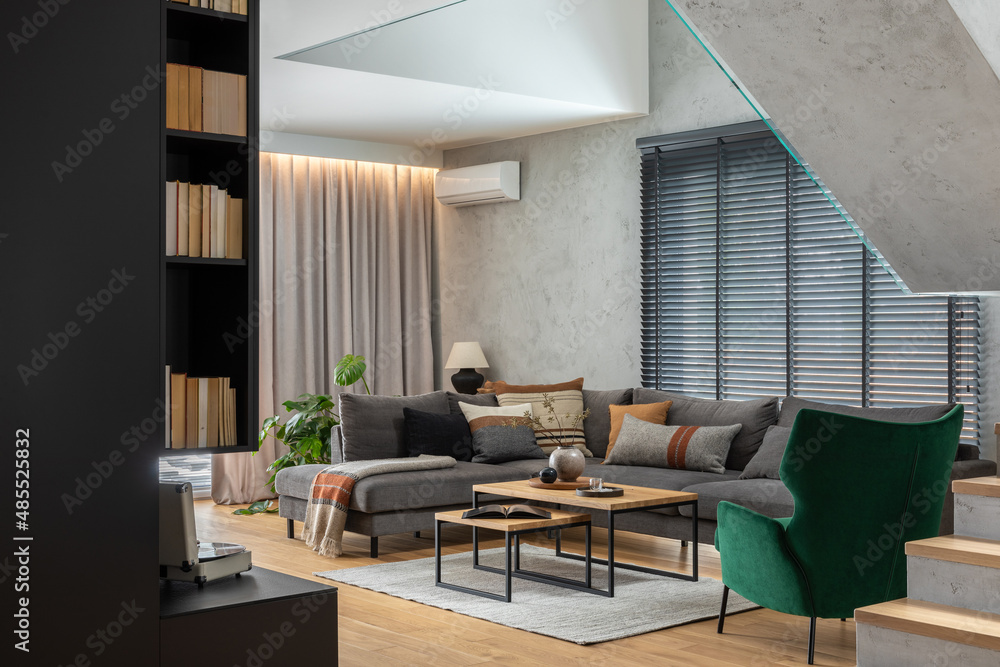 Stylish composition of living room interior with corner grey sofa