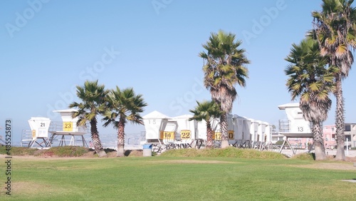 Lifeguard stand and palm tree, life guard tower for surfing on California beach. Summer pacific ocean in USA aesthetic. Iconic rescue baywatch station, coast lifesavers wachtower hut or house by sea.