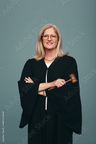 Female judge holding a gavel in a studio photo