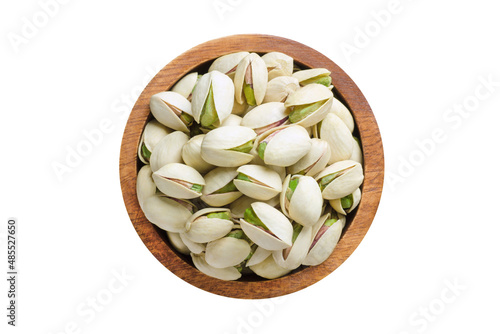shelled pistachio nuts in wooden bowl isolated on white background. Vegan food, top view. photo