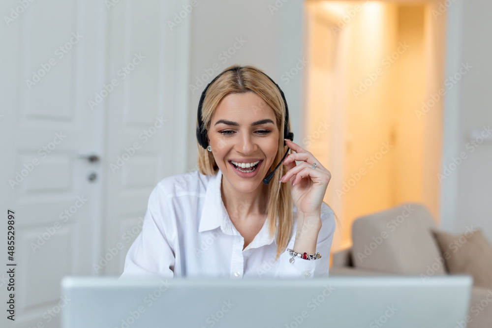 Happy young woman working on laptop while talking to customer on phone. Consulting corporate client in conversation with customer using computer. Service desk consultant talking in a call center. Happy young woman working on laptop while talking to customer on phone. Consulting corporate client in conversation with customer using computer. Service desk consultant talking in a call center.