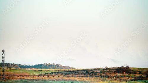 Time lapse of clouds moving over field country landscape and castle Mourao in the distance, district of Evora in Portugal Europe. photo